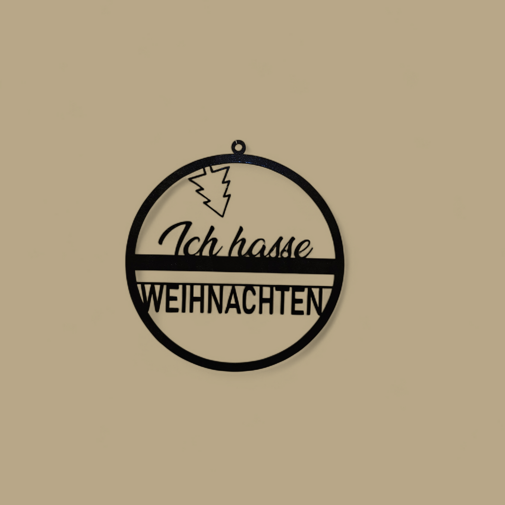 Eine kreisförmige Türdekoration, in der Mitte der Text "Ich hasse Weihnachten" in 2 verschiedenen Schriftarten, oben ist ein Weihnachtsbaum kopüber angebracht". Schwarz